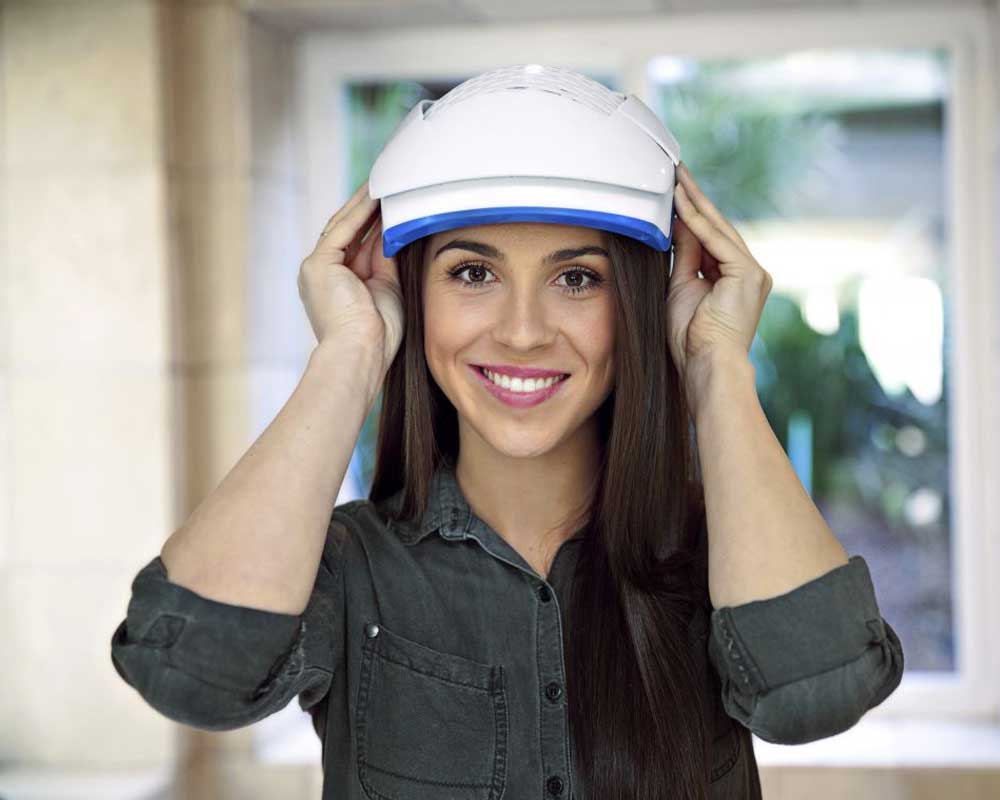 An image of a woman usinga Theradone Laser Light Therapy helmet